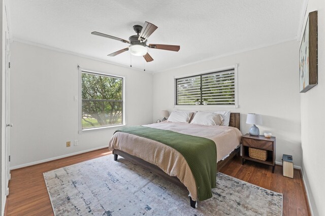 211 4th St, Dickinson, TX 77539 - bedroom with multiple windows, wood finished floors, ornamental molding, baseboards, and a textured ceiling
