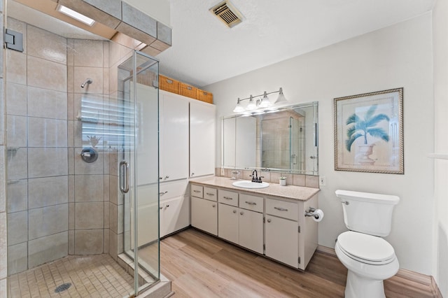 211 4th St, Dickinson, TX 77539 - bathroom featuring wood finished floors, a shower stall, toilet, and vanity