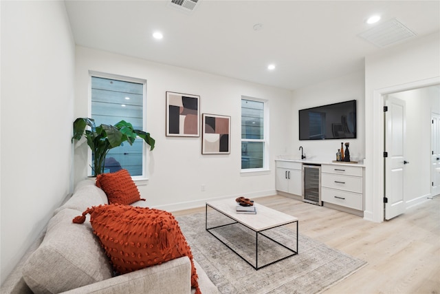 3731 Lydia St, Houston, TX 77021 - living area featuring beverage cooler, bar with sink, light wood finished floors, recessed lighting, and baseboards