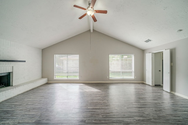 7218 Winding Trace Dr, Houston, TX 77086 - unfurnished living room featuring wood finished floors, plenty of natural light, ceiling fan, a textured ceiling, and a brick fireplace