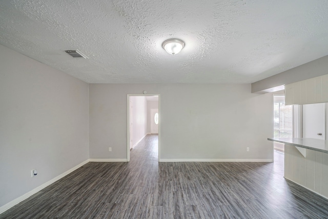 7218 Winding Trace Dr, Houston, TX 77086 - unfurnished room featuring dark wood-style flooring, a textured ceiling, and baseboards