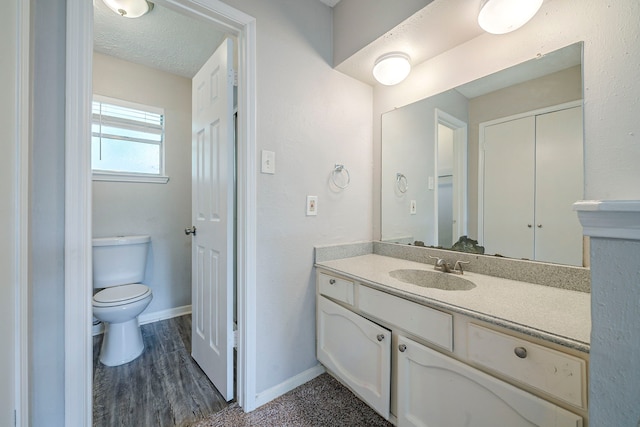 7218 Winding Trace Dr, Houston, TX 77086 - bathroom featuring toilet, vanity, baseboards, and wood finished floors