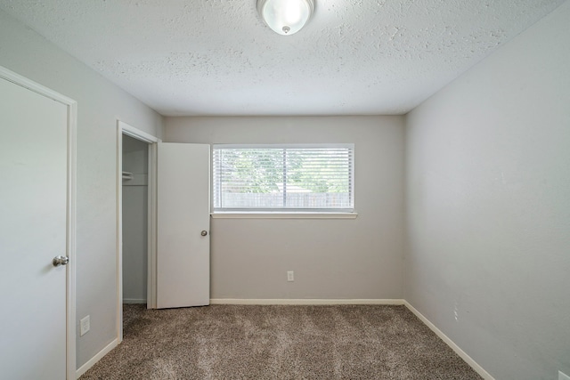 7218 Winding Trace Dr, Houston, TX 77086 - unfurnished bedroom with carpet floors, a textured ceiling, and baseboards