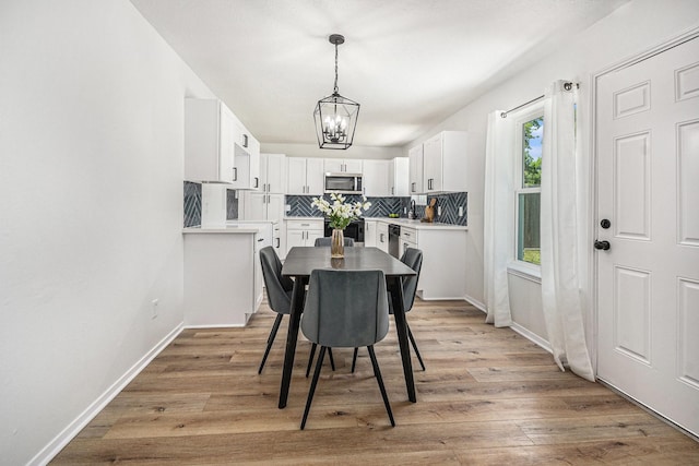 763 Voyager Dr, Houston, TX 77062 - dining room with a chandelier, light wood finished floors, and baseboards