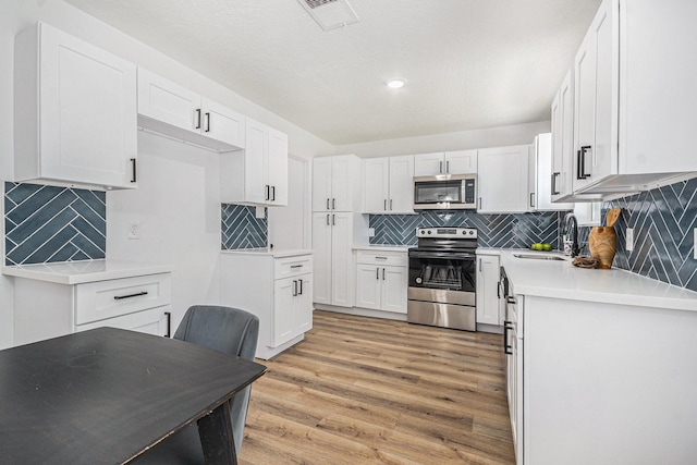 763 Voyager Dr, Houston, TX 77062 - kitchen featuring stainless steel appliances, tasteful backsplash, a sink, light wood finished floors, and recessed lighting