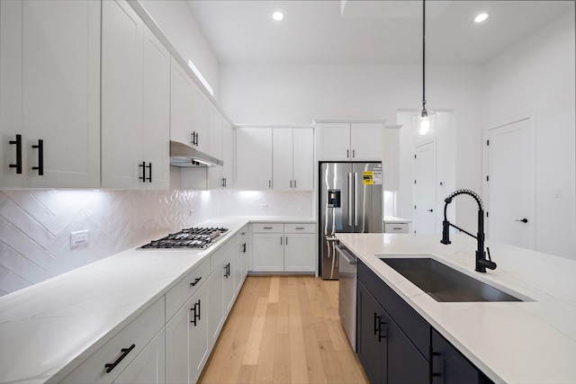 1435 Laird St, Houston, TX 77008 - kitchen with appliances with stainless steel finishes, a sink, decorative light fixtures, white cabinets, and under cabinet range hood