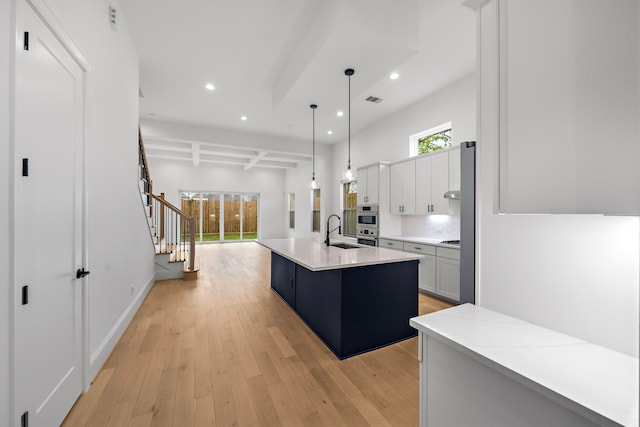 1435 Laird St, Houston, TX 77008 - kitchen with a sink, recessed lighting, light wood finished floors, an island with sink, and decorative light fixtures