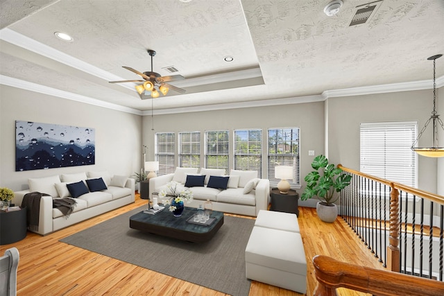 1380 Studer St, Houston, TX 77007 - living area with wood finished floors, a ceiling fan, a tray ceiling, a textured ceiling, and ornamental molding