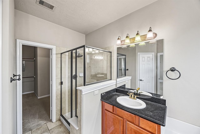 1380 Studer St, Houston, TX 77007 - bathroom featuring a stall shower, tile patterned floors, vanity, and a textured ceiling