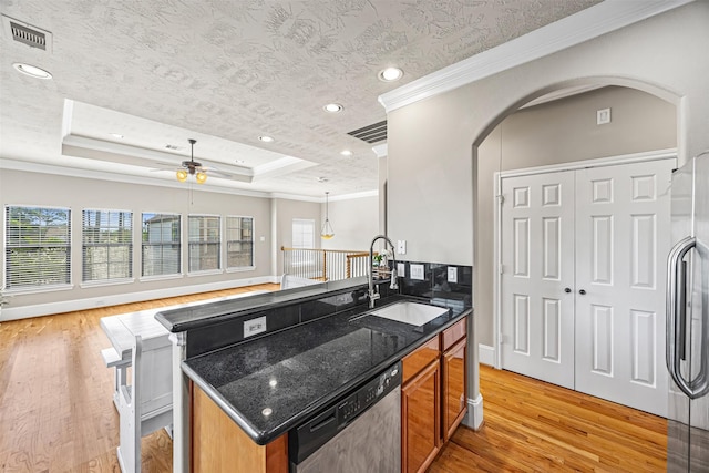1380 Studer St, Houston, TX 77007 - kitchen with stainless steel appliances, a sink, light wood finished floors, ornamental molding, and dark stone countertops