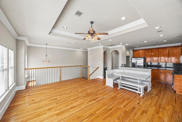 1380 Studer St, Houston, TX 77007 - kitchen featuring stainless steel fridge, light wood-type flooring, arched walkways, ceiling fan, and baseboards