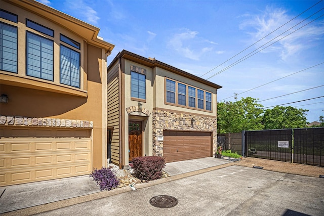 1380 Studer St, Houston, TX 77007 - view of front of home featuring stucco siding, stone siding, fence, an attached garage, and driveway