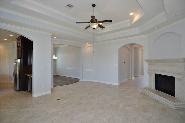 15818 Tremout Hollow Ln, Houston, TX 77044 - unfurnished living room with ceiling fan, a raised ceiling, arched walkways, a fireplace, and ornamental molding