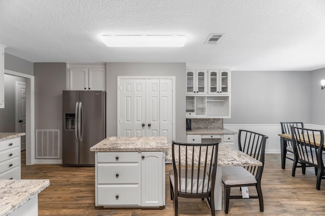 16610 Meadow Ln Unit Cr438, Danbury, TX 77534 - kitchen featuring stainless steel refrigerator with ice dispenser, white cabinets, a textured ceiling, glass insert cabinets, and dark wood-style floors