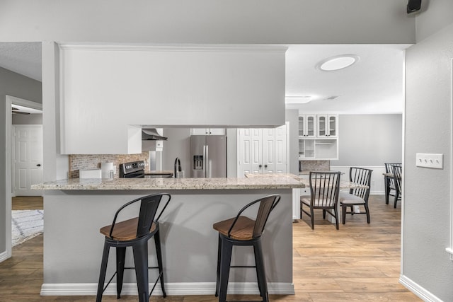 16610 Meadow Ln Unit Cr438, Danbury, TX 77534 - kitchen featuring stainless steel appliances, decorative backsplash, a kitchen bar, and a peninsula