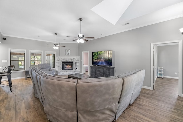 16610 Meadow Ln Unit Cr438, Danbury, TX 77534 - living area with a glass covered fireplace, wood finished floors, baseboards, a ceiling fan, and crown molding