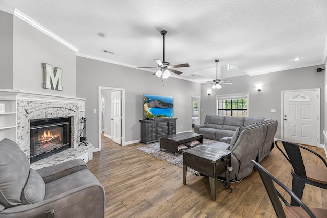 16610 Meadow Ln Unit Cr438, Danbury, TX 77534 - living area with crown molding, a ceiling fan, a textured ceiling, wood finished floors, and a glass covered fireplace