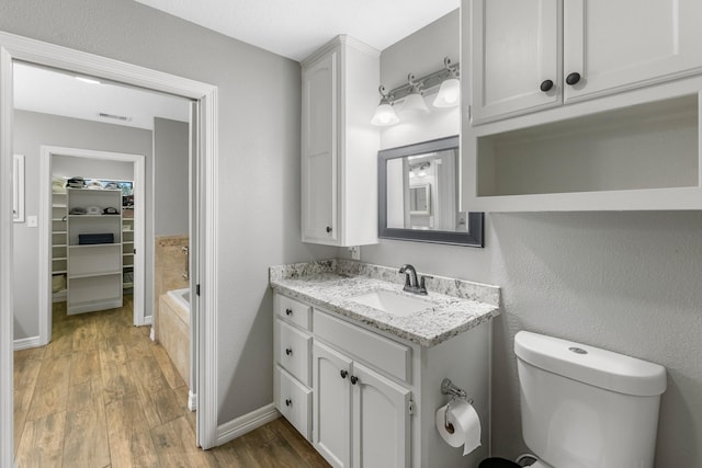 16610 Meadow Ln Unit Cr438, Danbury, TX 77534 - bathroom featuring wood finished floors, vanity, toilet, and a bath