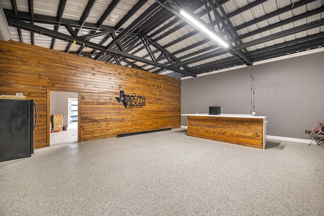 16610 Meadow Ln Unit Cr438, Danbury, TX 77534 - unfurnished living room featuring baseboards, wooden walls, and a towering ceiling