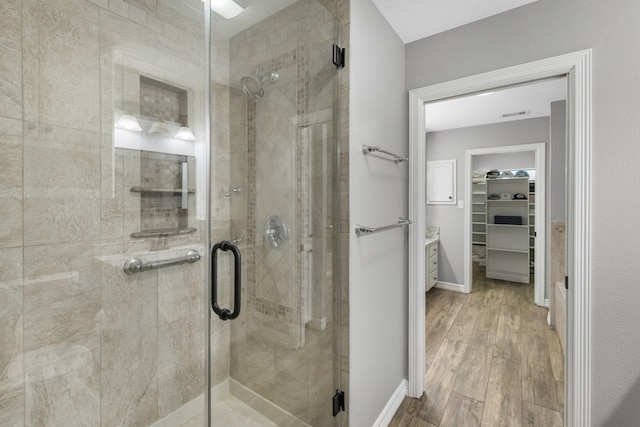 16610 Meadow Ln Unit Cr438, Danbury, TX 77534 - full bathroom featuring wood finished floors, a shower stall, a spacious closet, and vanity