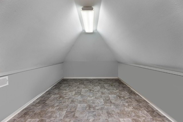 16610 Meadow Ln Unit Cr438, Danbury, TX 77534 - bonus room with vaulted ceiling, stone finish floors, and baseboards