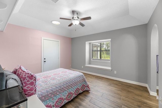 16610 Meadow Ln Unit Cr438, Danbury, TX 77534 - bedroom featuring wood finished floors, baseboards, a tray ceiling, ceiling fan, and a textured ceiling
