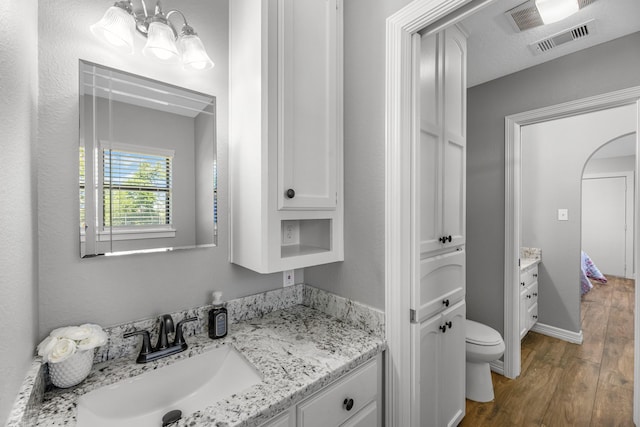 16610 Meadow Ln Unit Cr438, Danbury, TX 77534 - bathroom with vanity, wood finished floors, toilet, a chandelier, and baseboards