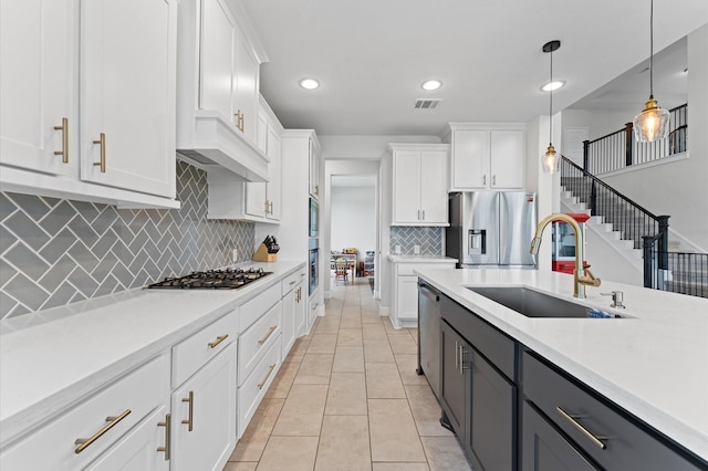 2006 Green Haven Ct, Missouri City, TX 77459 - kitchen with a sink, stainless steel appliances, light countertops, white cabinets, and hanging light fixtures