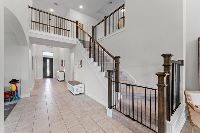 2006 Green Haven Ct, Missouri City, TX 77459 - entrance foyer featuring a high ceiling, tile patterned floors, arched walkways, baseboards, and stairs
