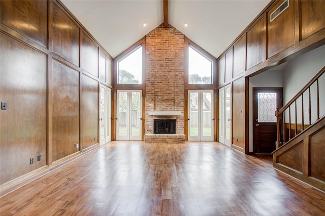 506 Windsor Glen Dr, Katy, TX 77450 - unfurnished living room with light wood-type flooring, high vaulted ceiling, beam ceiling, a brick fireplace, and stairs