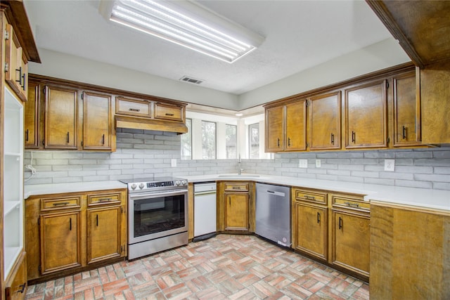 506 Windsor Glen Dr, Katy, TX 77450 - kitchen with stainless steel appliances, brick flooring, light countertops, and backsplash