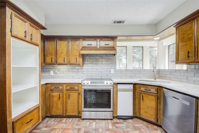 506 Windsor Glen Dr, Katy, TX 77450 - kitchen featuring stainless steel appliances, a sink, brick flooring, and tasteful backsplash