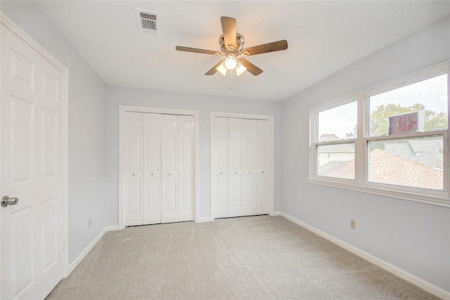 506 Windsor Glen Dr, Katy, TX 77450 - unfurnished bedroom with two closets, baseboards, carpet flooring, and a ceiling fan