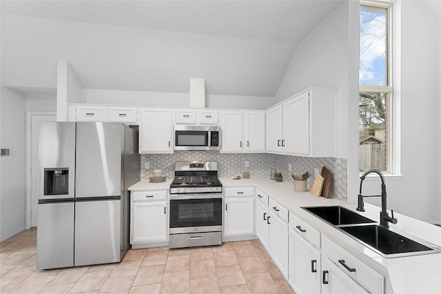 12319 Hamsfield Ct, Tomball, TX 77377 - kitchen with appliances with stainless steel finishes, backsplash, a sink, vaulted ceiling, and white cabinetry