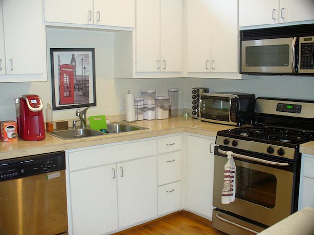 3501 Link Valley Dr Unit 1004, Houston, TX 77025 - kitchen with stainless steel appliances, light countertops, white cabinetry, and a sink