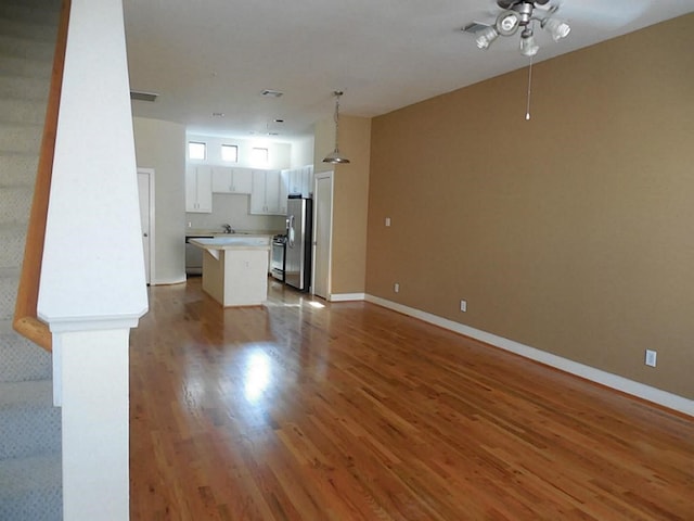 3501 Link Valley Dr Unit 1004, Houston, TX 77025 - unfurnished living room featuring a ceiling fan, wood finished floors, baseboards, and a sink
