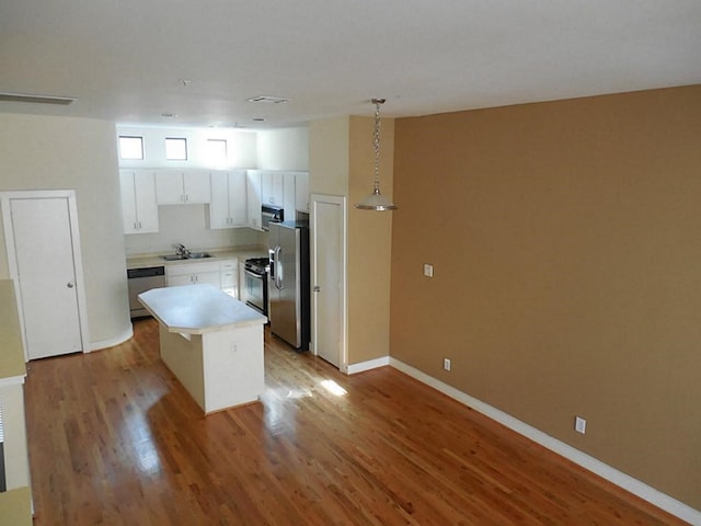 3501 Link Valley Dr Unit 1004, Houston, TX 77025 - kitchen with appliances with stainless steel finishes, light countertops, light wood-style flooring, white cabinetry, and a sink