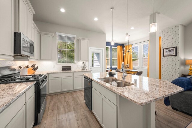 255 S Spotted Fern Dr, Montgomery, TX 77316 - kitchen featuring appliances with stainless steel finishes, a sink, light wood-style flooring, tasteful backsplash, and recessed lighting