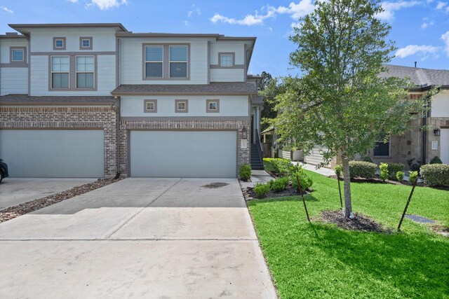 255 S Spotted Fern Dr, Montgomery, TX 77316 - townhome / multi-family property featuring an attached garage, brick siding, a front yard, and driveway