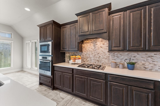 3319 Sky Run Ct, Missouri City, TX 77459 - kitchen featuring appliances with stainless steel finishes, vaulted ceiling, light marble finish floors, light countertops, and dark brown cabinetry