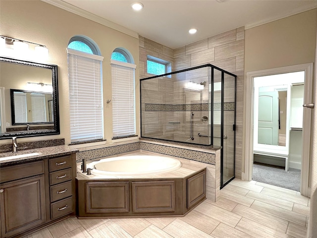 2308 Ellis Park Ln, Conroe, TX 77304 - bathroom with a stall shower, a garden tub, ornamental molding, vanity, and recessed lighting