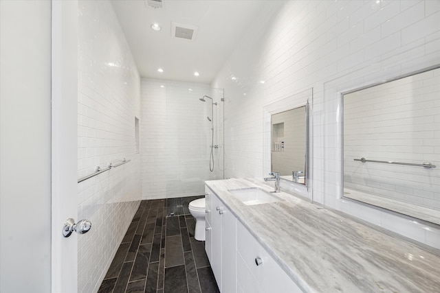 1851 Lexington St, Houston, TX 77098 - full bathroom with tile walls, toilet, tiled shower, vanity, and recessed lighting