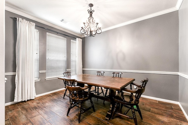 dining room featuring wood finished floors, ornamental molding, baseboards, and a chandelier