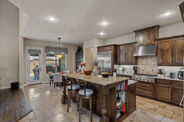 401 Bastrop Dr, Allen, TX 75013 - kitchen with stainless steel appliances, under cabinet range hood, stone tile floors, decorative backsplash, and baseboards
