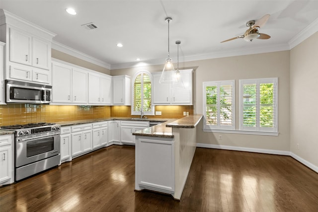 6635 Wanita Pl Unit B, Houston, TX 77007 - kitchen with stainless steel appliances, a peninsula, white cabinetry, a ceiling fan, and ornamental molding