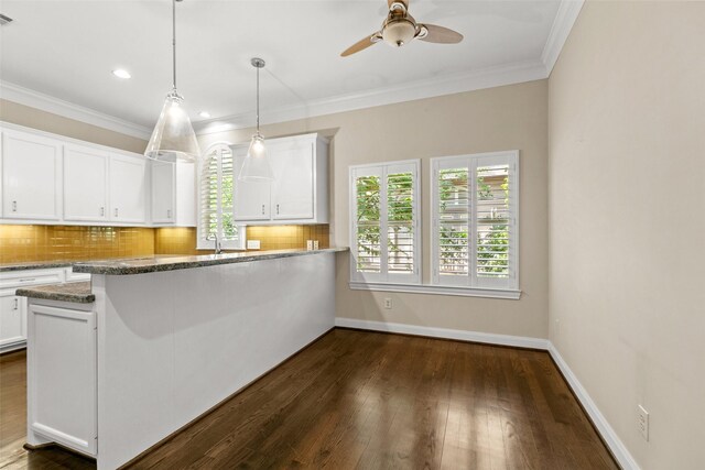6635 Wanita Pl Unit B, Houston, TX 77007 - kitchen with healthy amount of natural light, white cabinets, decorative backsplash, a ceiling fan, and ornamental molding