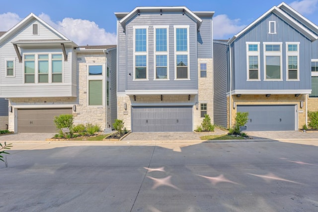10920 Keaton Landing Dr, Houston, TX 77043 - view of front facade with a garage, driveway, and stone siding
