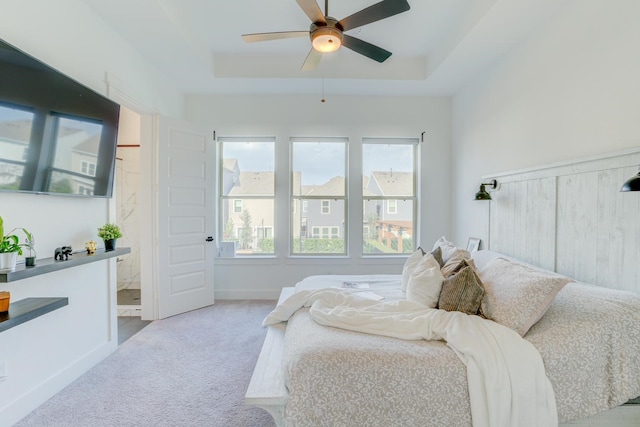 10920 Keaton Landing Dr, Houston, TX 77043 - carpeted bedroom featuring a tray ceiling, a ceiling fan, and ensuite bath