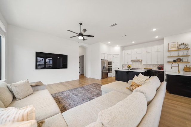 30246 Gold Finch Pl, Fulshear, TX 77441 - living area featuring arched walkways, ceiling fan, light wood-style flooring, and recessed lighting