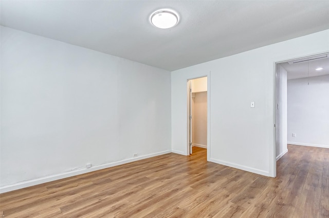 1316 Bailey St, Wharton, TX 77488 - unfurnished bedroom featuring attic access, light wood-style flooring, baseboards, a spacious closet, and a closet